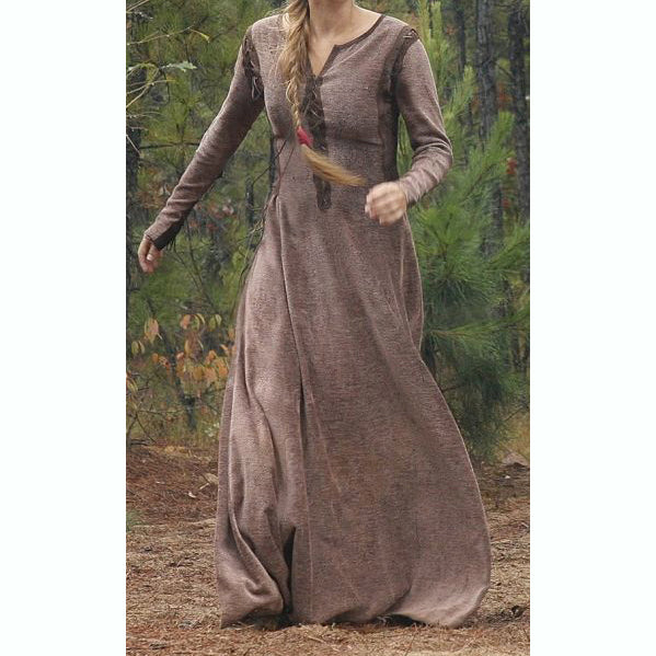 Woman wearing a long brown dress standing in a forest